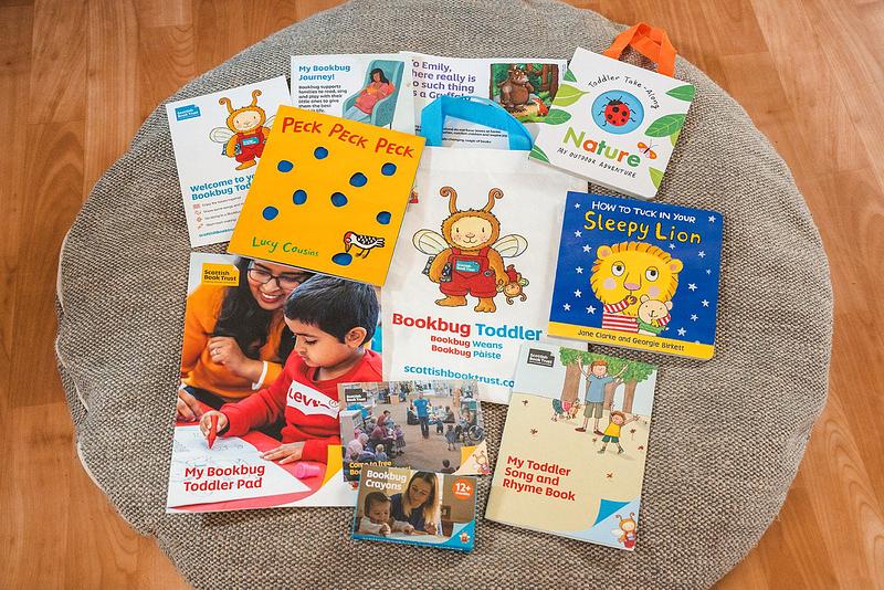 Contents of the 2024 Bookbug Toddler Bag spread out on a cushion